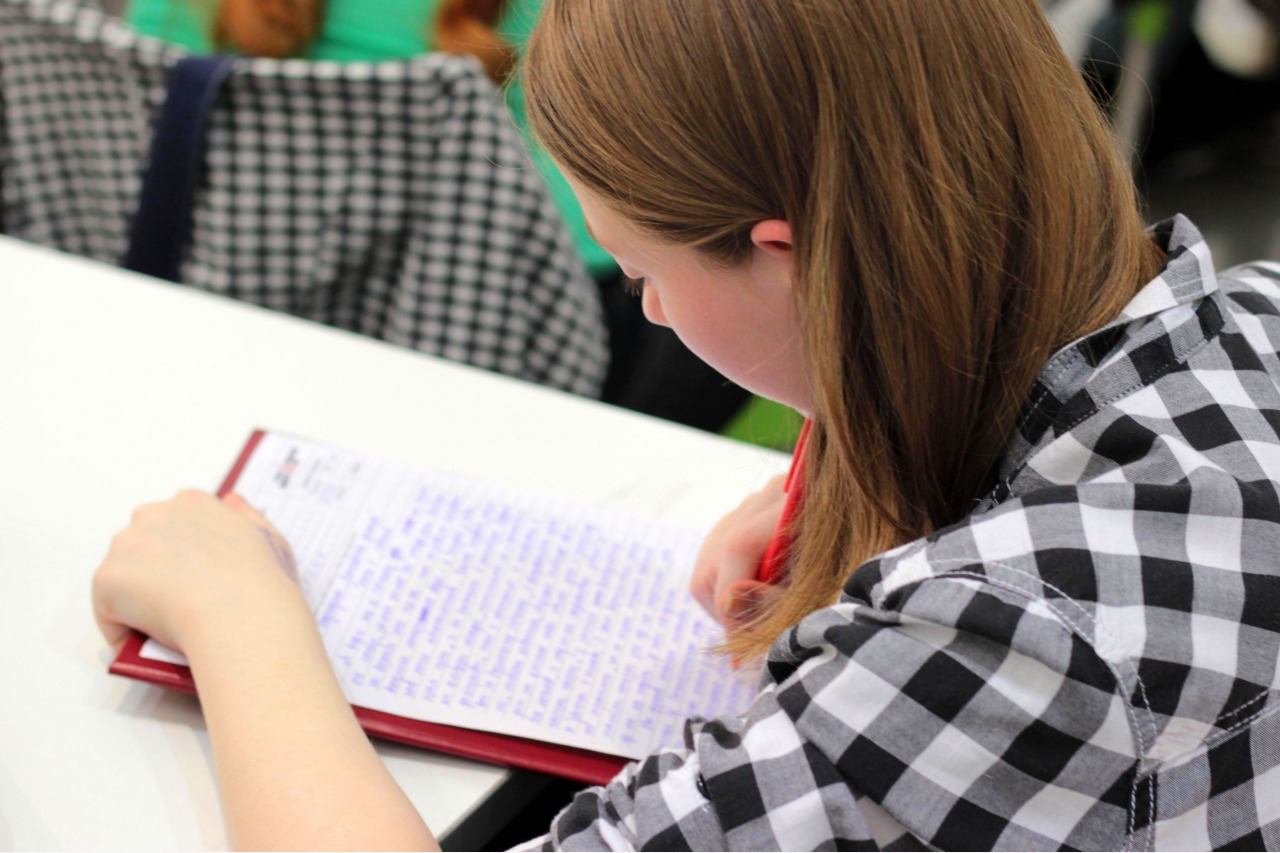 menina fazendo redação no caderno em aula